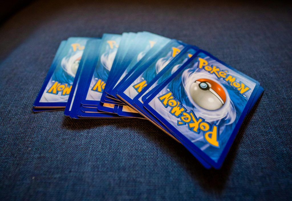 A set of Pokémon cards displayed on a blue surface, perfect for game enthusiasts.